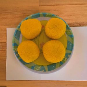 Close-up of beautifully garnished Rajbhog sweets with saffron, pistachio, and almond slivers.
