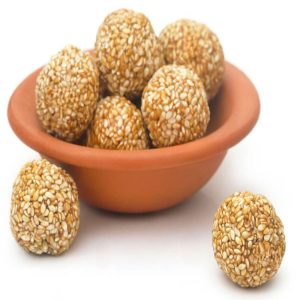 white til laddu: A traditional Indian sweet made from white sesame seeds, jaggery, and ghee, shaped into round laddu.